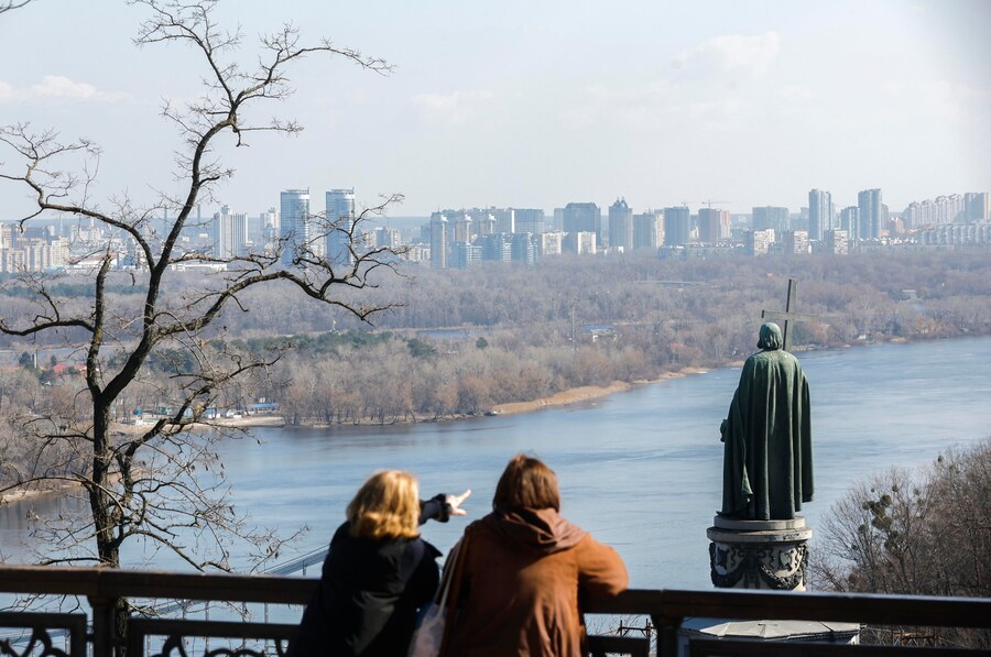Alcuni passanti osservano il fiume Dnepr e il monumento a San Volodymyr nel centro di Kiev, in Ucraina, il 20 marzo 2026. (EPA)