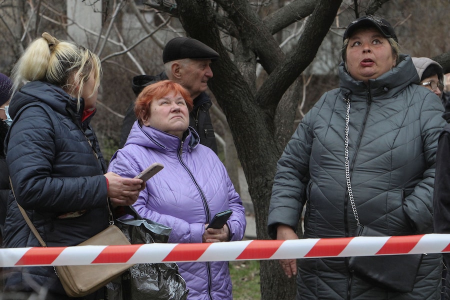 I residenti osservano il loro condominio colpito da un attacco con droni russi (REUTERS)