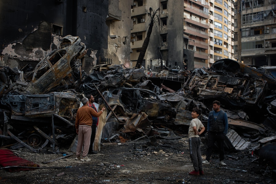 Residenti si radunano vicino ad auto ed edifici carbonizzati, sul luogo del raid aereo israeliano a Beirut, Libano (APN)