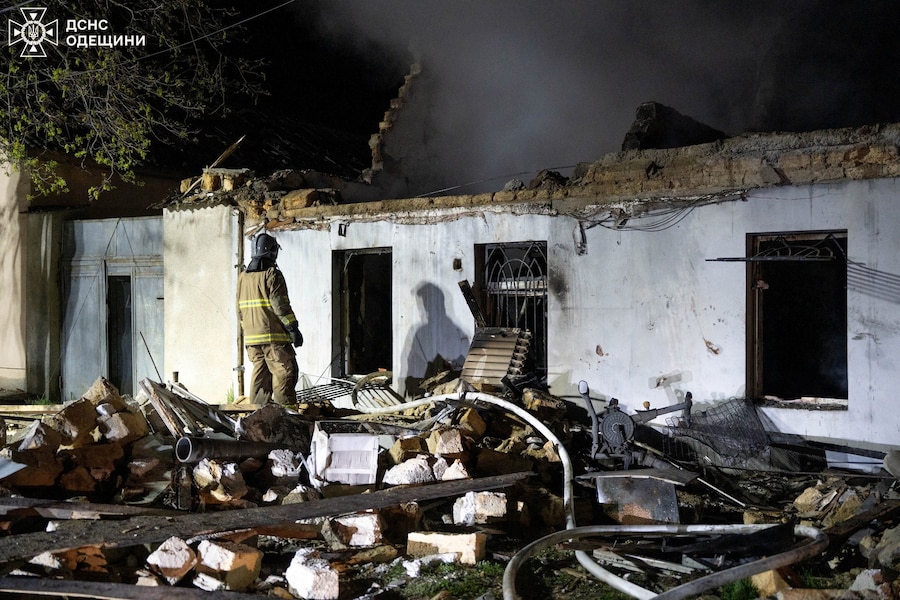 Un vigile del fuoco lavora sul luogo di un edificio residenziale colpito durante gli attacchi notturni dei droni russi a Odessa, Ucraina (via REUTERS)