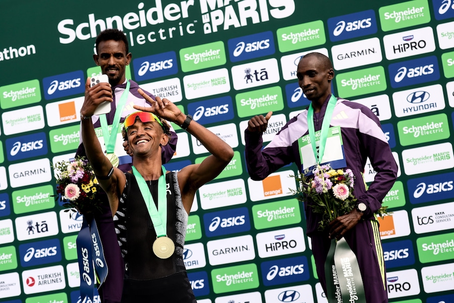 Il primo classificato Yemaneberhan Crippa dall’Italia (C) si scatta un selfie con il secondo classificato Bayelig Teshager dall’Etiopia (L) e il terzo classificato Sila Kiptoo dal Kenya (R) sul podio della Maratona di Parigi 2026 a Parigi (EPA)
