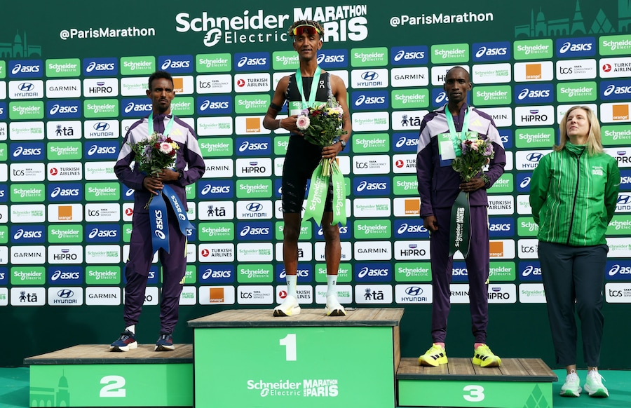 L’italiano Yemaneberhan Crippa festeggia sul podio dopo aver vinto la gara élite maschile insieme all’etiope Bayelig Teshager, secondo classificato, e al keniano Sila Kiptoo, terzo classificato (REUTERS)