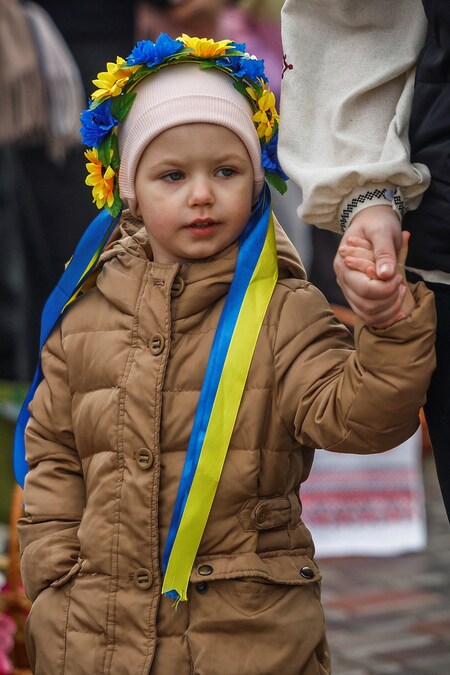 Una ragazza indossa una corona nei colori della bandiera ucraina mentre partecipa a una funzione in occasione della Pasqua ortodossa, durante una tregua di 32 ore dichiarata dalla Russia, nel contesto dell'attacco russo all'Ucraina, nei pressi della chiesa di Sant'Andrea nella città di Bucha, nella regione di Kiev, Ucraina, il 12 aprile 2026. REUTERS/Alina Smutko (REUTERS)