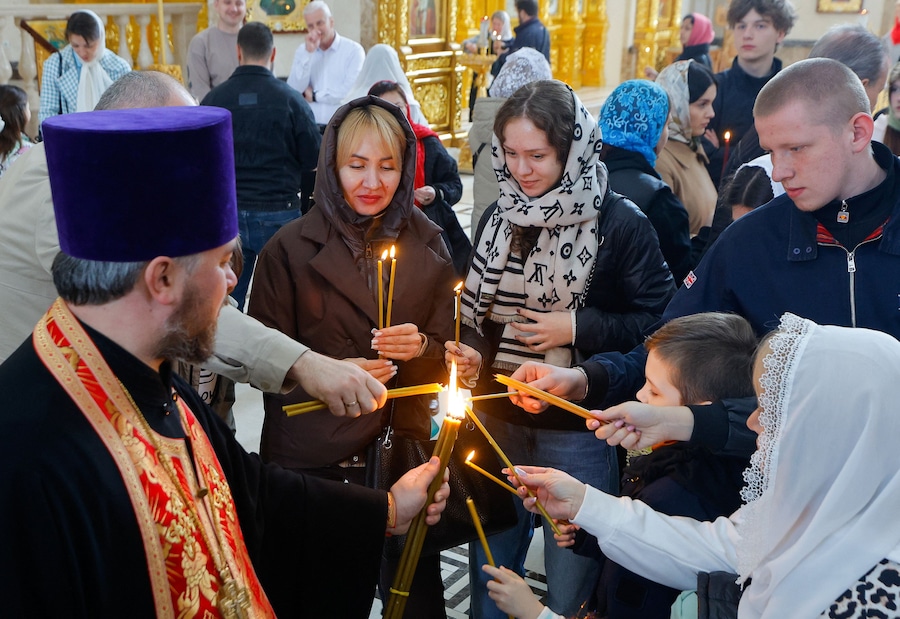 Un sacerdote distribuisce il Fuoco Sacro ai fedeli dopo il suo arrivo alla Cattedrale dei Santi Pietro e Fevronia durante le celebrazioni pasquali ortodosse, nel contesto del conflitto tra Russia e Ucraina, a Donetsk, città ucraina sotto il controllo russo, il 12 aprile 2026. REUTERS/Alexander Ermochenko (REUTERS)