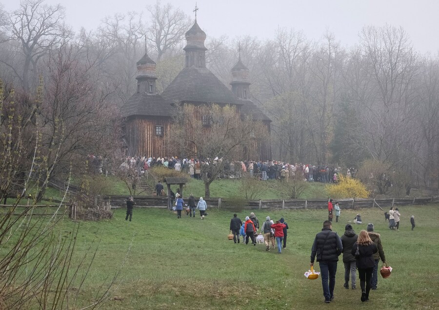 I fedeli portano i cestini pasquali a una cerimonia di benedizione dei dolci pasquali e dei cestini con i cibi tradizionali dopo la funzione pasquale ortodossa, a seguito di una tregua di 32 ore dichiarata dalla Russia, nel contesto dell'attacco russo all'Ucraina, nei pressi della chiesa del Museo Nazionale di Architettura Popolare a Kiev, Ucraina, il 12 aprile 2026. REUTERS/Gleb Garanich (REUTERS)