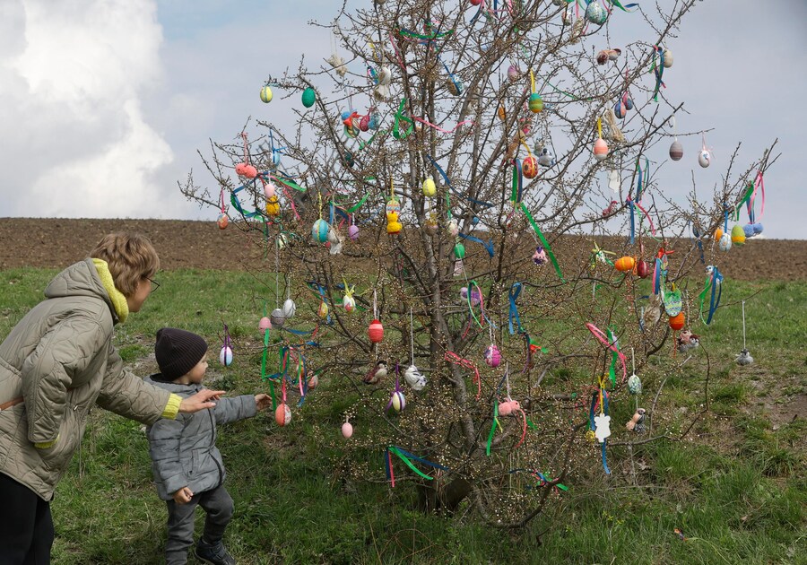 Alcuni fedeli ucraini si radunano vicino a un albero addobbato con uova di Pasqua per celebrare la Pasqua al Museo di Architettura Popolare ed Etnografia nel villaggio di Pyrohovo, nei pressi di Kiev, Ucraina, il 12 aprile 2026, mentre è in corso l'invasione russa. EPA/SERGEY DOLZHENKO (EPA)