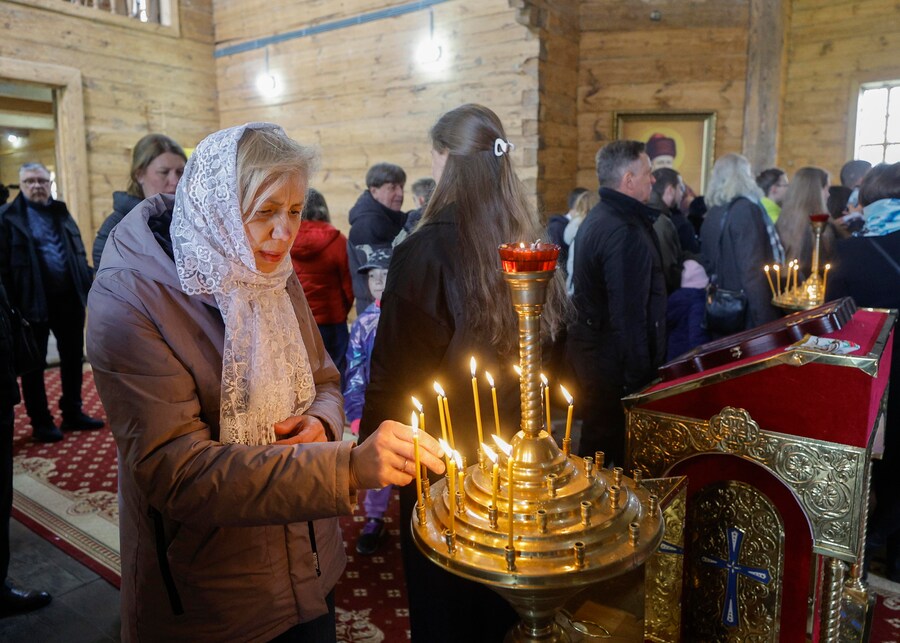 Alcuni fedeli ucraini accendono candele nella Chiesa dell'Arcangelo San Michele mentre si riuniscono per celebrare la Pasqua al Museo di Architettura Popolare ed Etnografia nel villaggio di Pyrohovo, vicino a Kiev, in Ucraina, il 12 aprile 2026, nel pieno dell'invasione russa in corso. EPA/SERGEY DOLZHENKO (EPA)