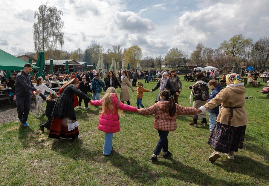 I fedeli ucraini ballano mentre si riuniscono per celebrare la Pasqua al Museo di Architettura Popolare ed Etnografia nel villaggio di Pyrohovo, vicino a Kiev, in Ucraina, il 12 aprile 2026, nel pieno dell'invasione russa in corso. EPA/SERGEY DOLZHENKO (EPA)