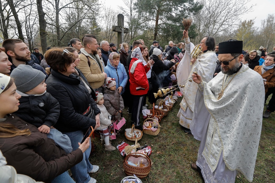 I sacerdoti ucraini benedicono i fedeli e i loro cestini contenenti uova dipinte e kulichi, un dolce pasquale tradizionale, nei pressi della chiesa dell’Arcangelo San Michele nel Museo di Architettura Popolare ed Etnografia nel villaggio di Pyrohovo, vicino a Kiev, Ucraina, il 12 aprile 2026, mentre i cristiani ortodossi ucraini celebrano la Pasqua nel mezzo dell’invasione russa in corso. EPA/SERGEY DOLZHENKO (EPA)