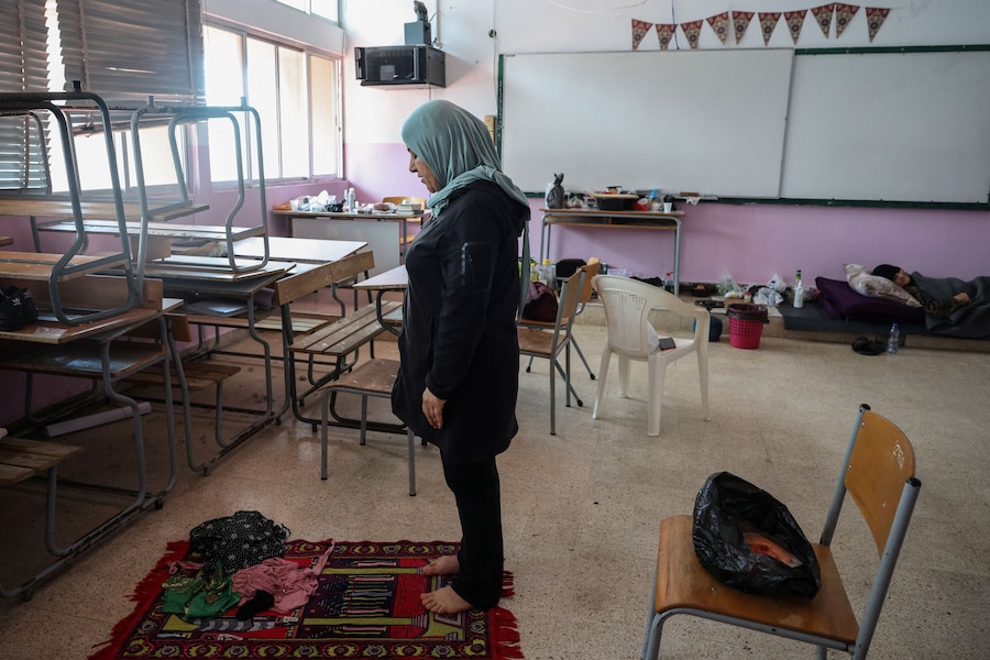 Nadia Abou Khalil, 46 anni, originaria del villaggio meridionale di Qlaileh, prega in un'aula di una scuola superiore trasformata in centro di accoglienza per sfollati, dove vive con la sorella e la madre disabile, a Tiro, in Libano, il 12 aprile 2026. REUTERS/Louisa Gouliamaki (REUTERS)