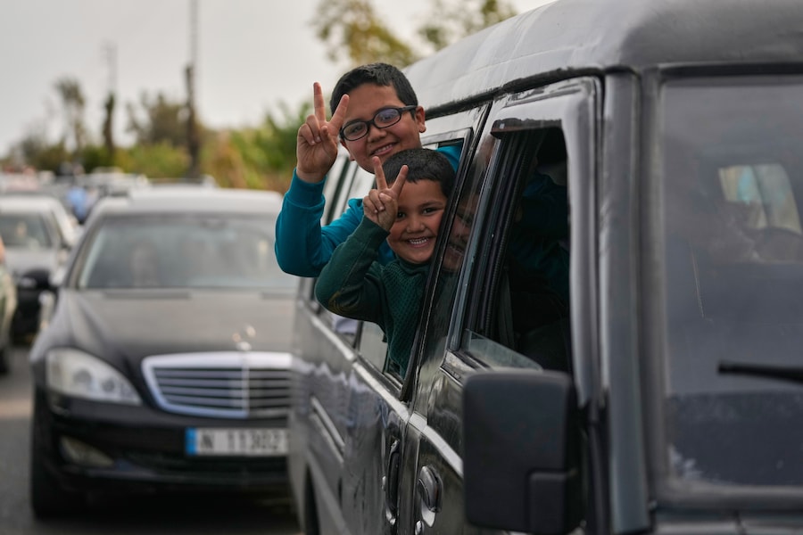 Ragazzi sfollati fanno il segno della vittoria mentre tornano con le loro famiglie al loro villaggio dopo un cessate il fuoco tra Hezbollah e Israele, a Qasmiyeh vicino alla città di Tiro, nel sud del Libano (APN)