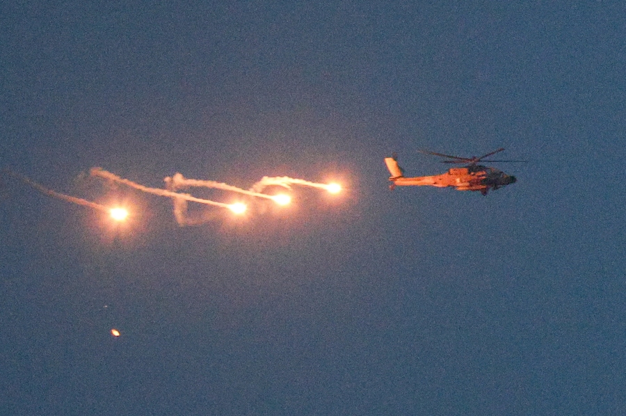 Un elicottero israeliano rilascia razzi illuminanti mentre sorvola il Libano, visto dal lato israeliano del confine con il Libano (REUTERS)