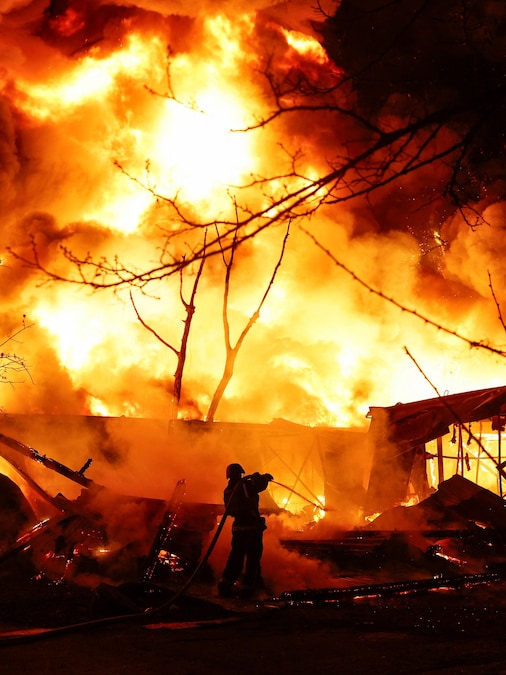 Un vigile del fuoco lavora sul luogo di un magazzino di materiali riciclabili colpito da un missile russo a Kiev, Ucraina (REUTERS)