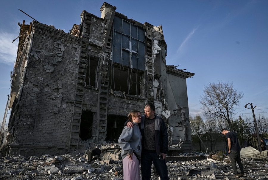 Due residenti si trovano sul luogo di una chiesa colpita da un attacco aereo russo, nel contesto dell'offensiva russa contro l'Ucraina, a Zaporizhzhia. (REUTERS/Stringer)