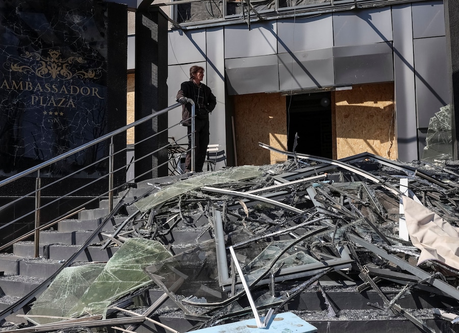 Un uomo si trova nei pressi di un hotel colpito da un missile e da un drone russi, a Kiev. (REUTERS/Anatolii Stepanov)