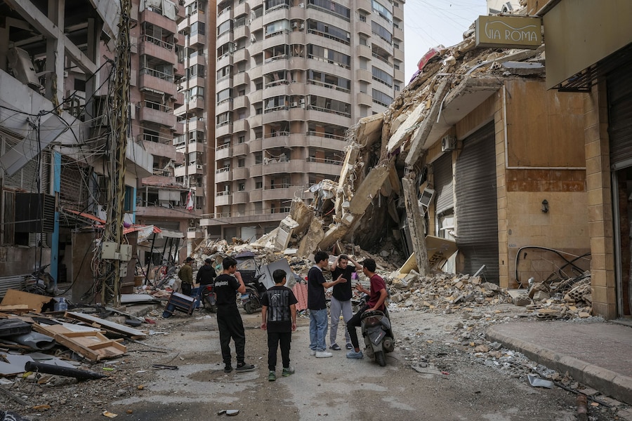 Ragazzi accanto a un edificio distrutto, dopo l'entrata in vigore di una tregua di 10 giorni tra Libano e Israele, nella periferia sud di Beirut, in Libano, il 18 aprile 2026. (REUTERS)