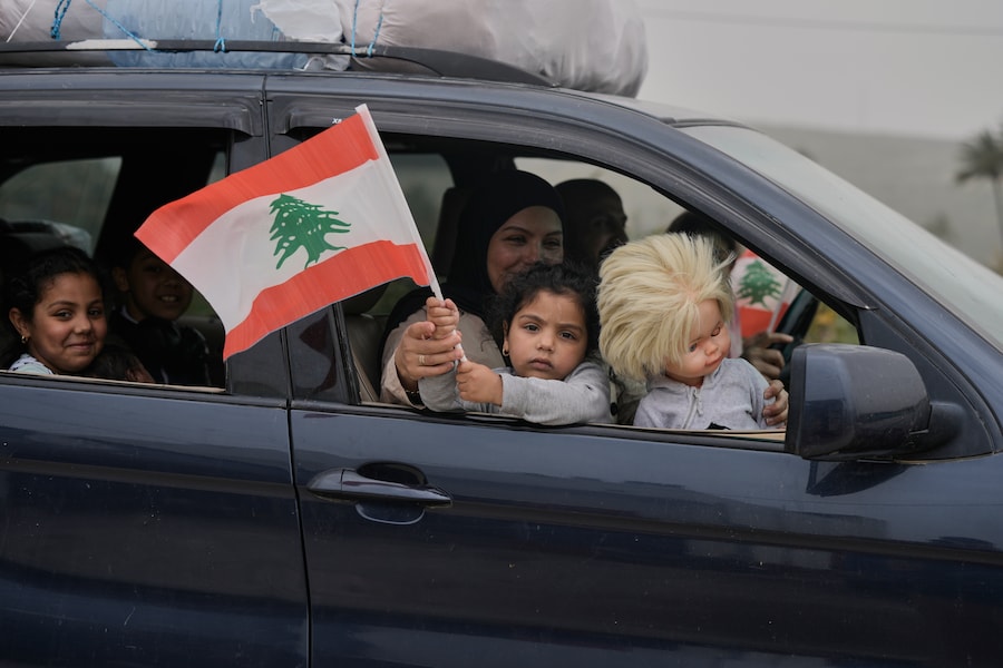 Una bambina sventola una bandiera libanese mentre torna con la sua famiglia al proprio villaggio, il secondo giorno del cessate il fuoco tra Hezbollah e Israele a Qasmiyeh, nei pressi della città di Tiro, nel sud del Libano, sabato 18 aprile 2026. (APN)