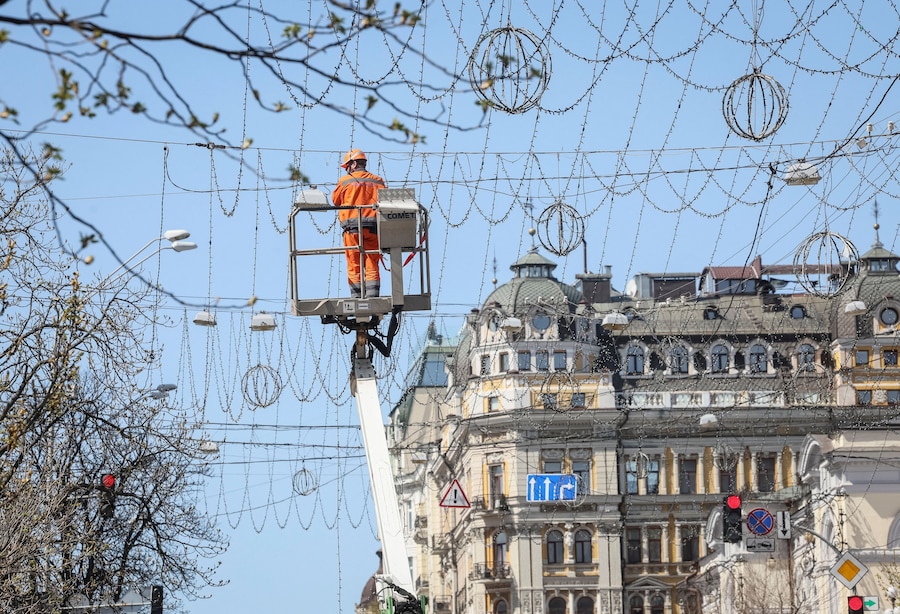 Un operaio comunale ripara l'illuminazione stradale a Kiev, mentre la Russia sta attaccando l'Ucraina. (REUTERS/Gleb Garanich)