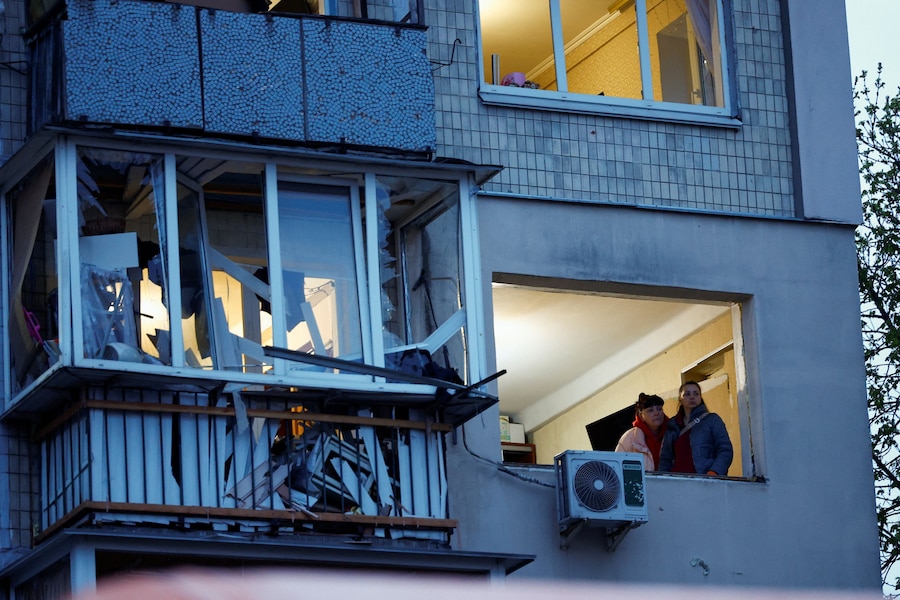 Dall'interno di un edificio danneggiato, alcune donne guardano fuori dalla finestra nel luogo colpito da un missile russo, a Kiev. (REUTERS/Alina Smutko)
