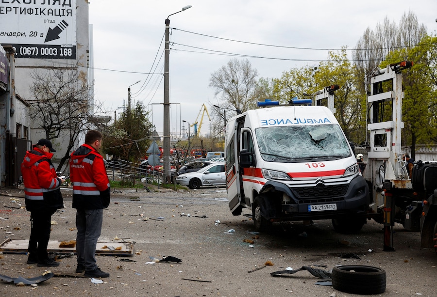 I paramedici sono in piedi accanto a un'ambulanza danneggiata durante un attacco missilistico russo, a Kiev. (REUTERS/Valentyn Ogirenko)