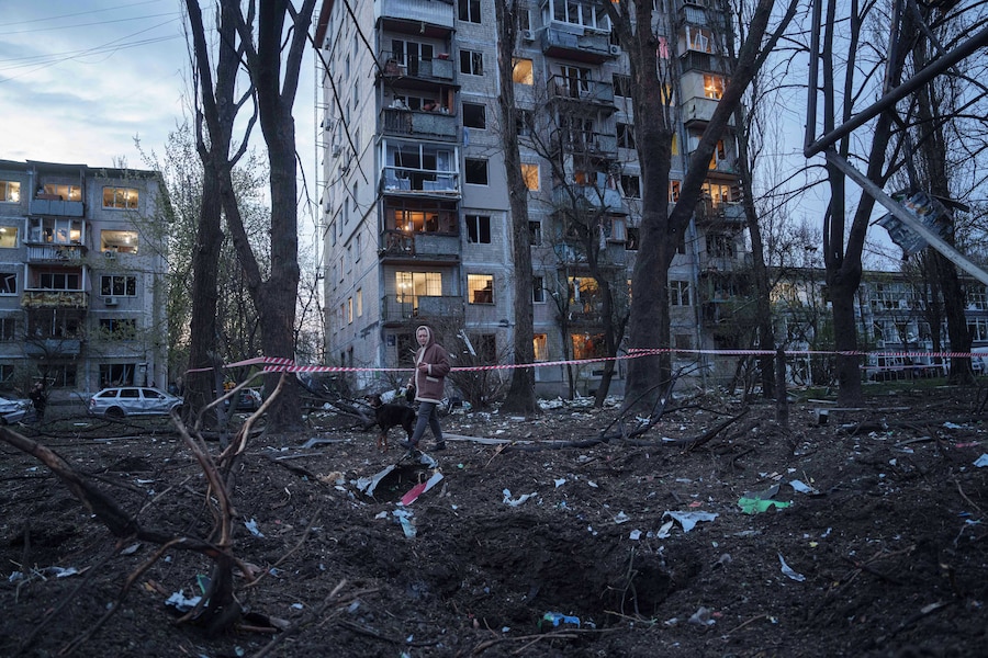 Una donna con un cane cammina tra le macerie di una casa danneggiata in seguito a un attacco russo contro una zona residenziale a Kiev. (AP Photo/Evgeniy Maloletka/ Associated Press/ LaPresse/APN)
