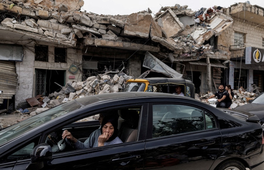 Una residente sfollata osserva i danni causati dai bombardamenti israeliani mentre torna a casa in auto dopo l'entrata in vigore di una tregua di 10 giorni tra il Libano e Israele, a Nabatieh, in Libano. (REUTERS/Zohra Bensemra)