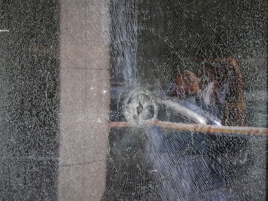 I residenti si riflettono nella vetrina di un supermercato con un foro di proiettile nel punto in cui ieri si è verificata una sparatoria, a Kiev. (REUTERS/Gleb Garanich)