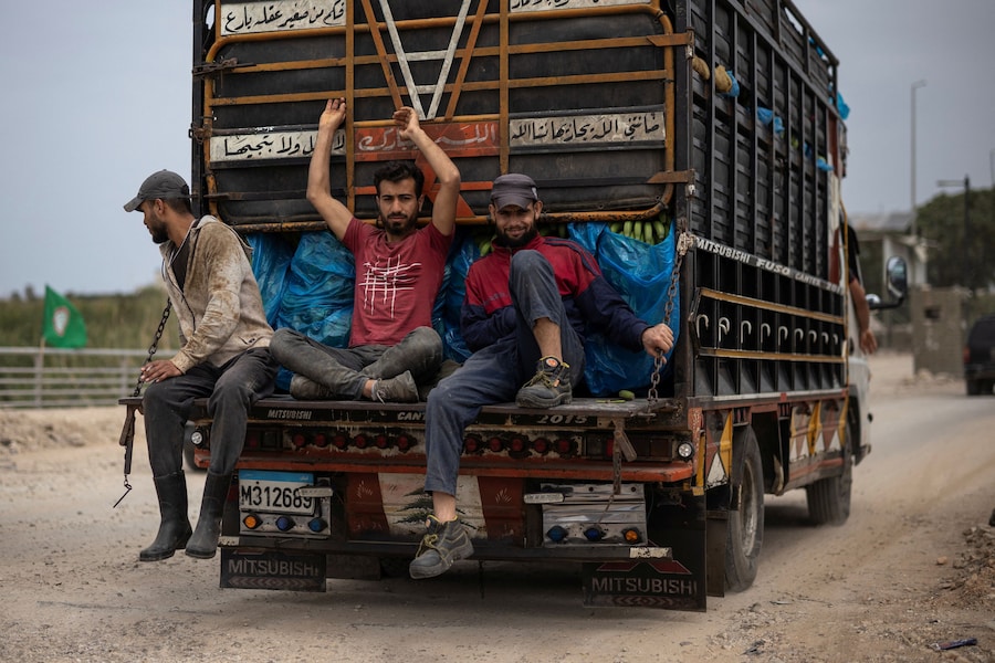 Alcune persone viaggiano in auto mentre gli sfollati tornano alle loro case attraversando il ponte che collega il Libano meridionale al resto del Paese, colpito in precedenza da un attacco israeliano, nel corso di una tregua di dieci giorni tra Libano e Israele, a Qasmiyeh, in Libano. (REUTERS/Marko Djurica)