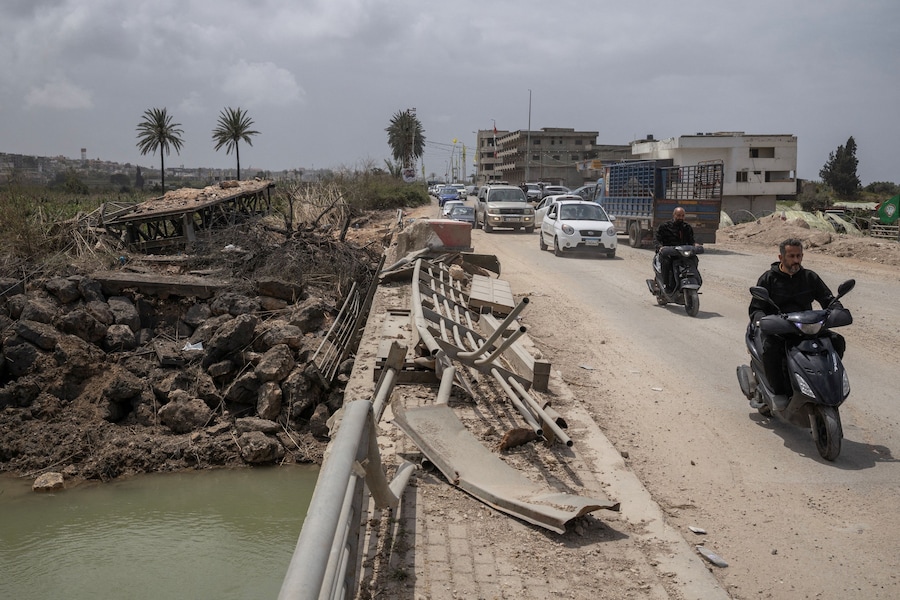 A Qasmiyeh, in Libano, alcune persone viaggiano in auto mentre gli sfollati tornano alle loro case attraversando il ponte che collega il Libano meridionale al resto del Paese, colpito in precedenza da un attacco israeliano, nel corso di una tregua di 10 giorni tra Libano e Israele. (REUTERS/Marko Djurica)