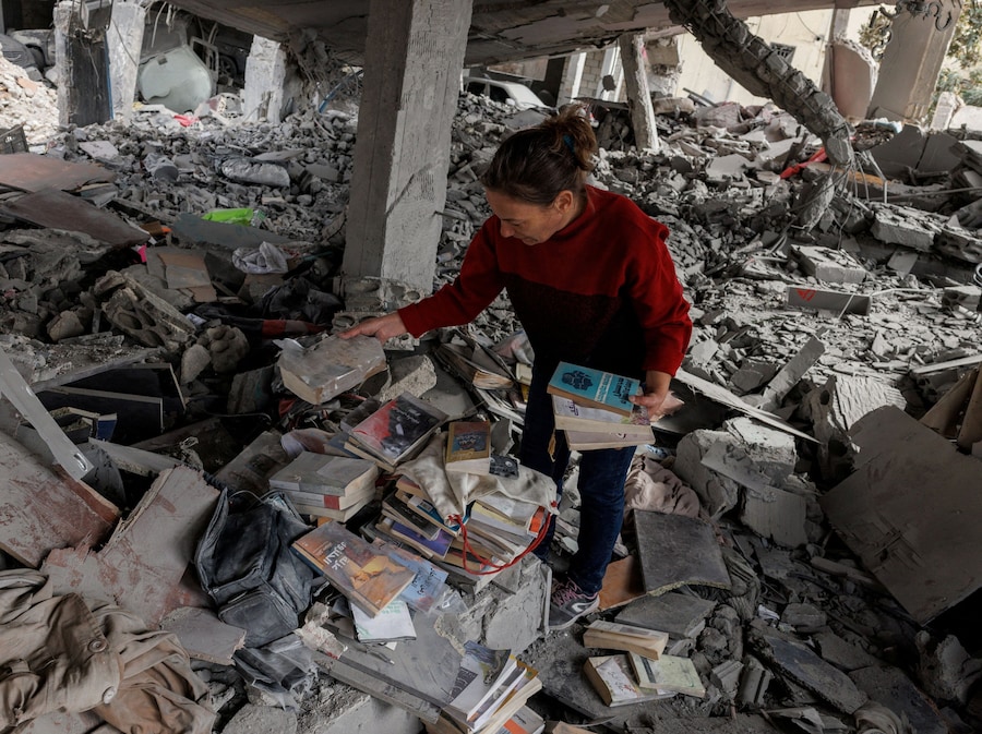 Katy Maroue, 47 anni, raccoglie libri dalle macerie della sua casa, che secondo lei è stata danneggiata da un attacco israeliano, mentre piange la distruzione della sua biblioteca, dopo essere tornata da Sidone, dove si era rifugiata, per recuperare i propri effetti personali, nel corso di una tregua di 10 giorni tra Libano e Israele, a Zrarieh, in Libano. (REUTERS/Zohra Bensemra)