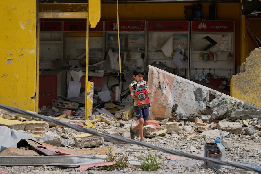 Un ragazzo trasporta scatole contenenti apparecchiature elettroniche dal negozio distrutto del padre, nella città di Nabatiyeh, nel sud del Libano. (AP Photo/Mohammed Zaatari / Associated Press/ LaPresse /APN)