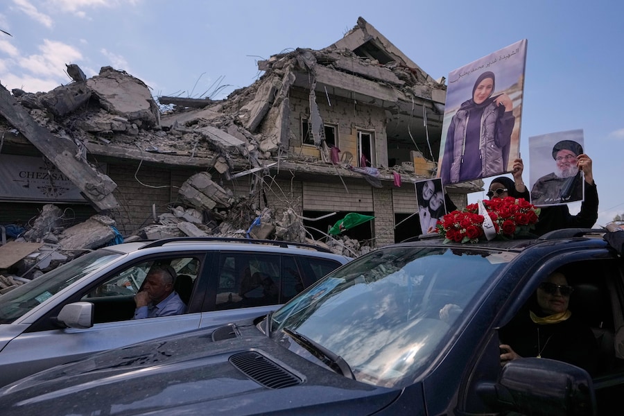 Una donna regge il ritratto di un parente ucciso nella guerra tra Hezbollah e Israele durante un funerale di massa, nel villaggio di Bazouriyeh, nel sud del Libano (APN)