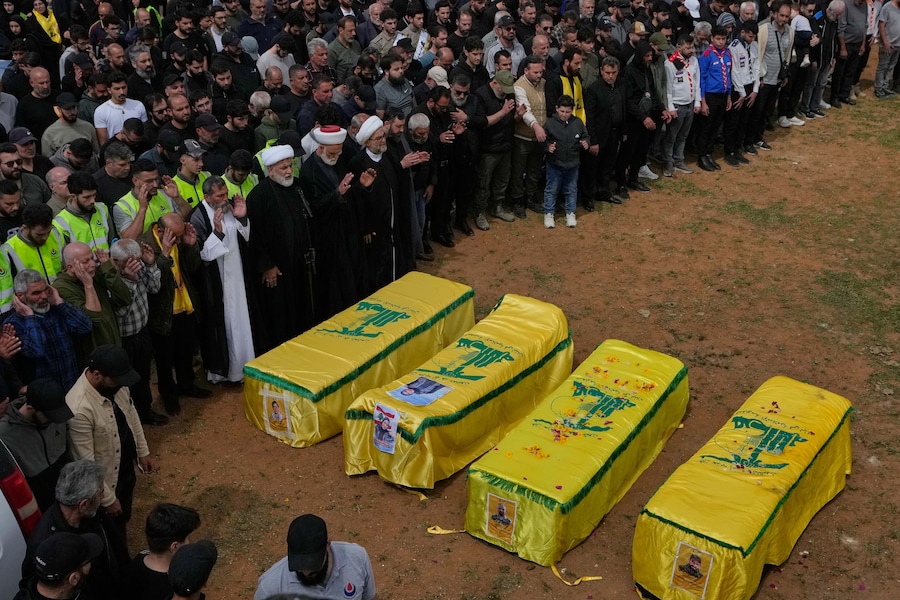 I partecipanti al funerale pregano sulle bare dei combattenti di Hezbollah e dei civili uccisi nella guerra tra Hezbollah e Israele durante un funerale di massa nel villaggio di Bazouriyeh, nel sud del Libano (APN)