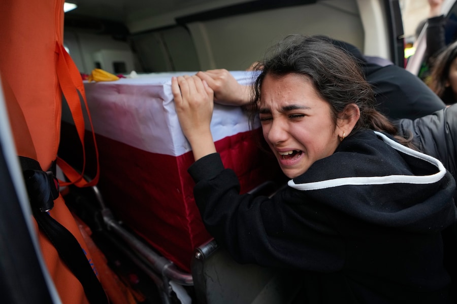 Una ragazza piange sulla bara di un parente ucciso nella guerra tra Hezbollah e Israele durante un funerale di massa nel villaggio di Bazouriyeh, nel sud del Libano (APN)