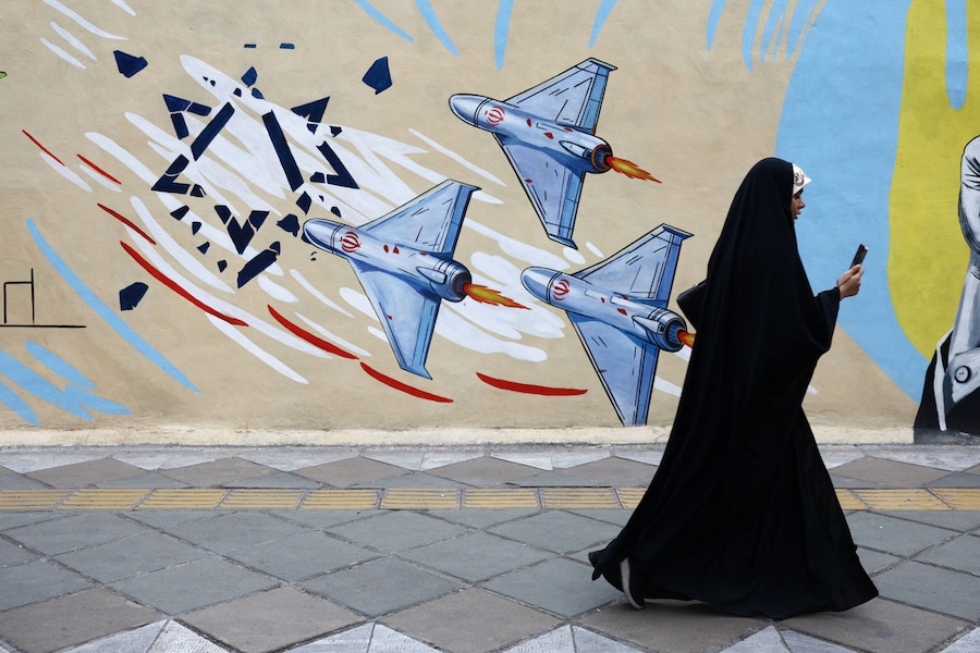 Una donna cammina accanto a un murale anti-israeliano in una strada, durante il cessate il fuoco tra Stati Uniti e Iran, a Teheran, Iran (via REUTERS)