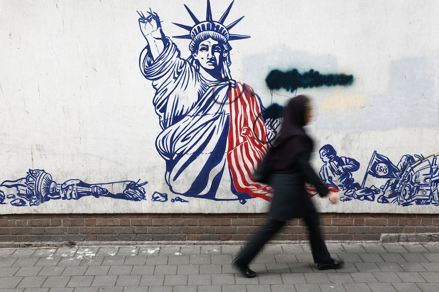 Una donna passa davanti a un murale anti-americano su una strada, durante il cessate il fuoco tra Stati Uniti e Iran, a Teheran, Iran (via REUTERS)