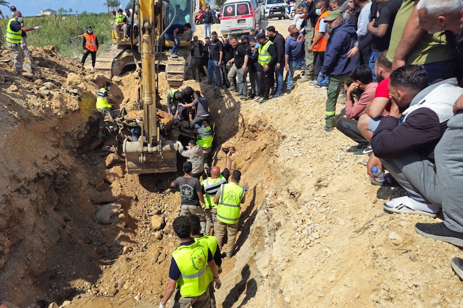 I soccorritori lavorano per recuperare i corpi di due vittime sul luogo di un attacco israeliano a un ponte, a Qasmiyeh, nel Libano meridionale (REUTERS)