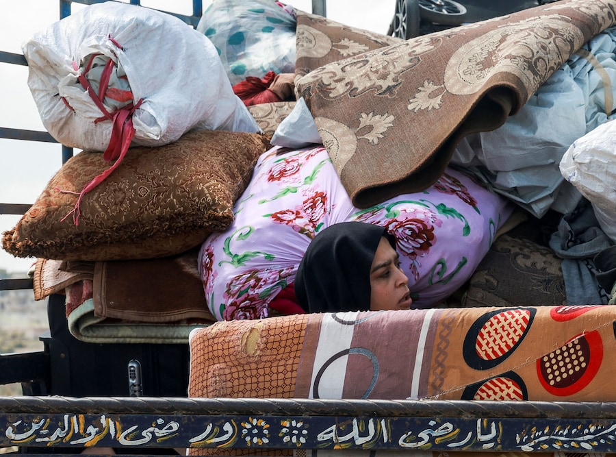 Una donna sfollata viaggia sul retro di un camion carico di effetti personali diretta verso casa, nel sud del Libano, durante un cessate il fuoco di 10 giorni tra Libano e Israele, a Qasmiyeh, nel sud del Libano (REUTERS)