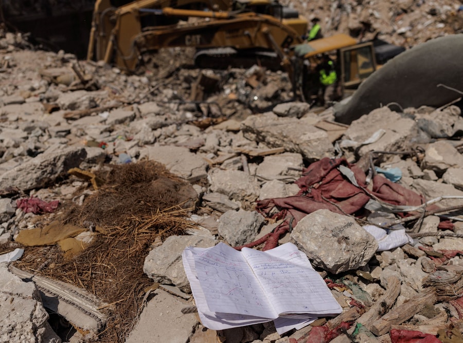 Un quaderno giace tra le macerie mentre i membri della protezione civile continuano a cercare corpi sotto un edificio colpito da un attacco israeliano poco prima del cessate il fuoco, durante una tregua di 10 giorni tra Libano e Israele, a Tire, nel sud del Libano (REUTERS)