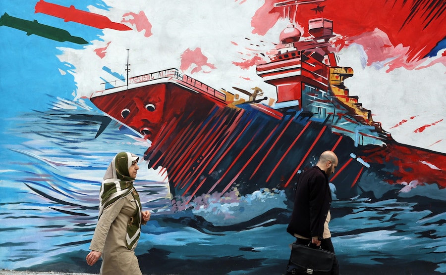 Iraniani camminano davanti a un murale anti-USA e anti-Israele in una strada di Teheran, Iran (EPA)