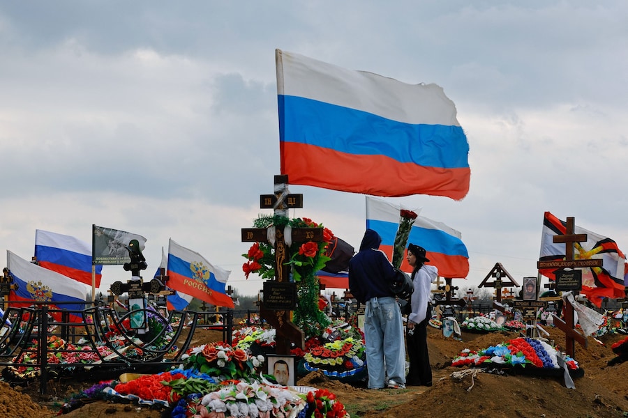Alcune persone visitano la tomba di un militare russo ucciso nel corso del conflitto tra Russia e Ucraina, in un cimitero alla periferia di Donetsk, città ucraina controllata dalla Russia (REUTERS)