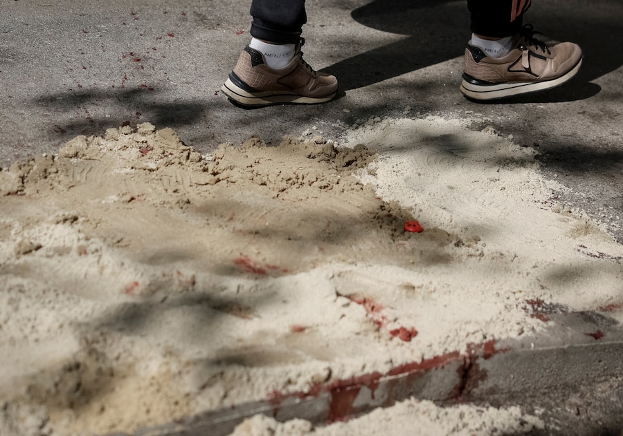 Un residente passa accanto a tracce di sangue coperte di sabbia a Kiev, Ucraina (REUTERS)