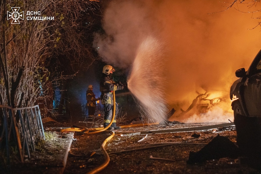I vigili del fuoco spengono le auto in fiamme nel sito di una zona residenziale colpita durante gli attacchi notturni dei droni russi a Sumy, Ucraina (via REUTERS)
