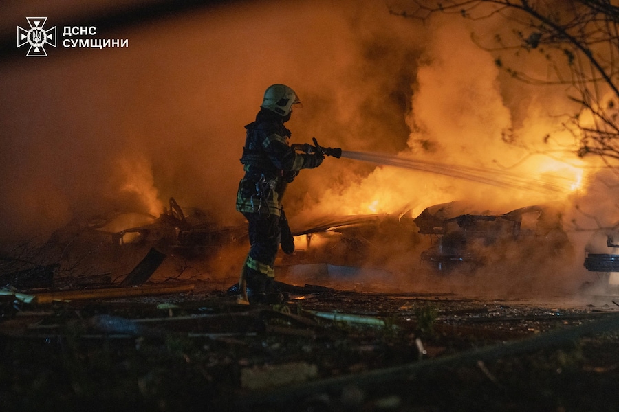 Un vigile del fuoco spegne le auto in fiamme nel sito di una zona residenziale colpita durante gli attacchi notturni dei droni russi a Sumy, Ucraina (via REUTERS)