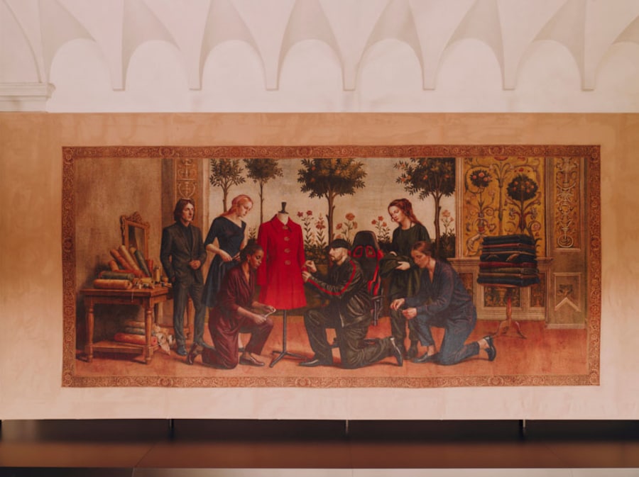 In occasione del Fuorisalone 2026, Gucci presenta “Gucci Memoria”, una mostra immersiva curata da Demna presso i Chiostri di San Simpliciano a Milano. Concepite come una narrazione continua, le installazioni ripercorrono i 105 anni di storia della maison, riflettendone l’identità in evoluzione pur rimanendo ancorate alle sue origini fiorentine. Distribuita negli spazi del chiostro, la mostra riunisce una serie di installazioni che spaziano dagli arazzi a un ambiente botanico ispirato al motivo Flora, fino a elementi interattivi, tra cui distributori automatici progettati su misura. Nel loro insieme, questi elementi danno vita a una scenografia stratificata in cui diversi linguaggi espressivi entrano in dialogo. Al centro di Gucci Memoria si trova un ciclo di dodici arazzi, concepiti come una cronaca visiva della maison. Radicati in una tradizione artigianale storicamente legata a Firenze, ciascun arazzo traduce un momento significativo della storia di Gucci in una composizione ricca e articolata. La narrazione culmina nel presente, con gli ultimi arazzi che inquadrano la direzione attuale della maison sotto Demna, chiudendo idealmente il cerchio all’interno dello studio, dove convergono artigianalità, sperimentazione e creazione collettiva.