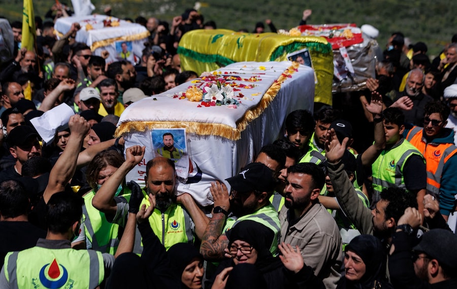 I funerali di alcuni combattenti di Hezbollah e dei membri della protezione civile uccisi durante il conflitto con Israele, i cui corpi sono stati riesumati da tombe provvisorie per essere sepolti nel loro villaggio natale, nel corso di una tregua di dieci giorni tra Libano e Israele, nel villaggio di Aitit, nel sud del Libano, il 22 aprile 2026. (REUTERS)