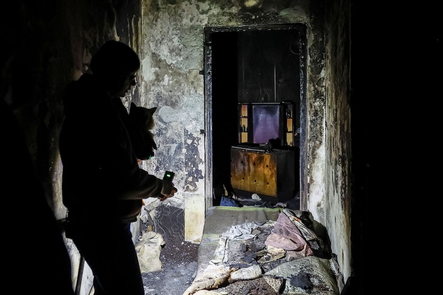 Valentyna Ananenko, 58 anni, moglie di Oleksii Ananenko, insignito del titolo di Eroe dell’Ucraina per il ruolo svolto nel 1986 in una missione sotto il quarto reattore della centrale nucleare di Cernobyl, visita l’appartamento distrutto dal fuoco della sua vicina Nataliia Khodemchuk, 73 anni, uccisa in un attacco con droni russi il 14 novembre 2025. (REUTERS)