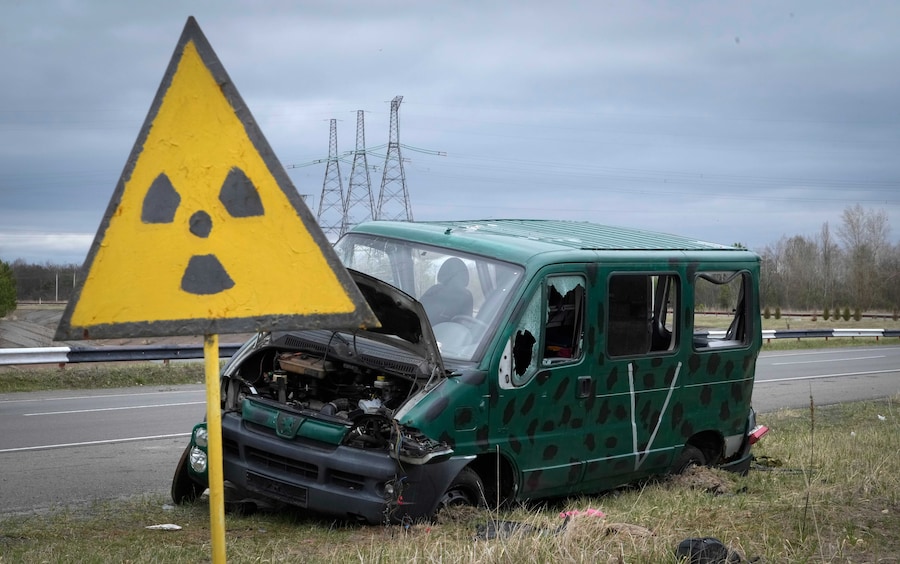 Un cartello di pericolo radiazioni vicino ai resti di un veicolo dell'esercito russo nei pressi della centrale nucleare di Chernobyl, a Chernobyl, in Ucraina. (APN)