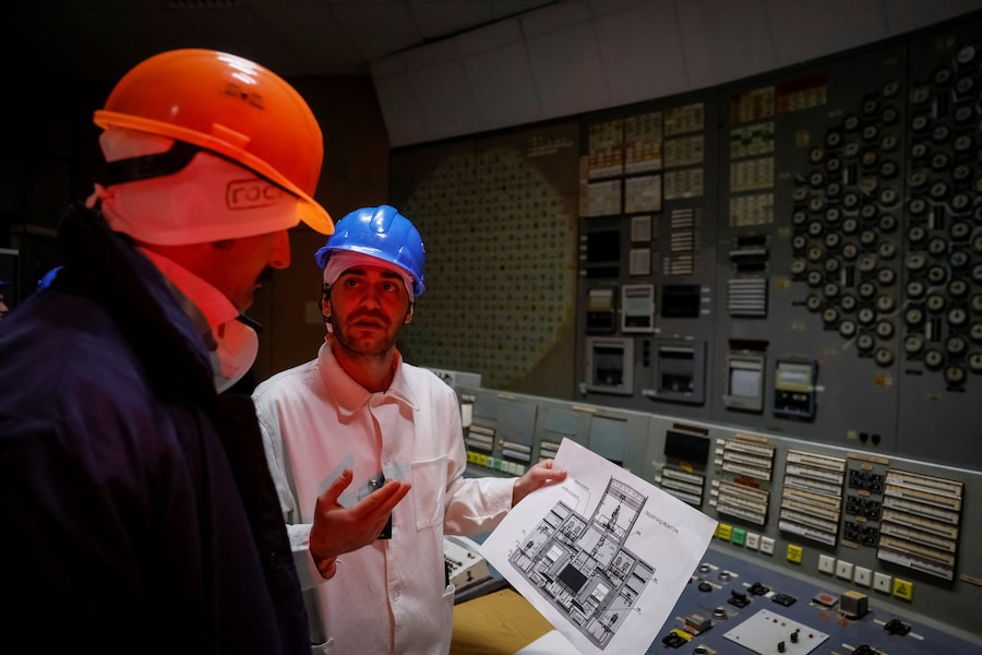 Un dipendente parla con un giornalista in una sala di controllo del terzo reattore, attualmente fermo, presso la centrale nucleare di Cernobyl, mentre la Russia sta attaccando l'Ucraina, nella regione di Kiev. (REUTERS/Gleb Garanich)