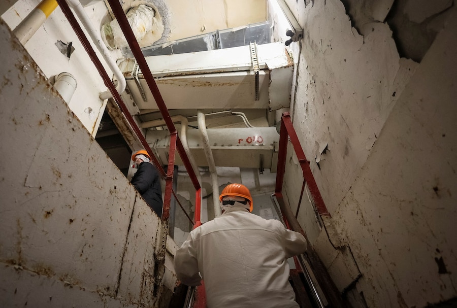 Alcuni dipendenti salgono le scale vicino al quarto reattore danneggiato della centrale nucleare di Cernobyl, mentre la Russia attacca l'Ucraina, nella regione di Kiev. (REUTERS/Gleb Garanich)